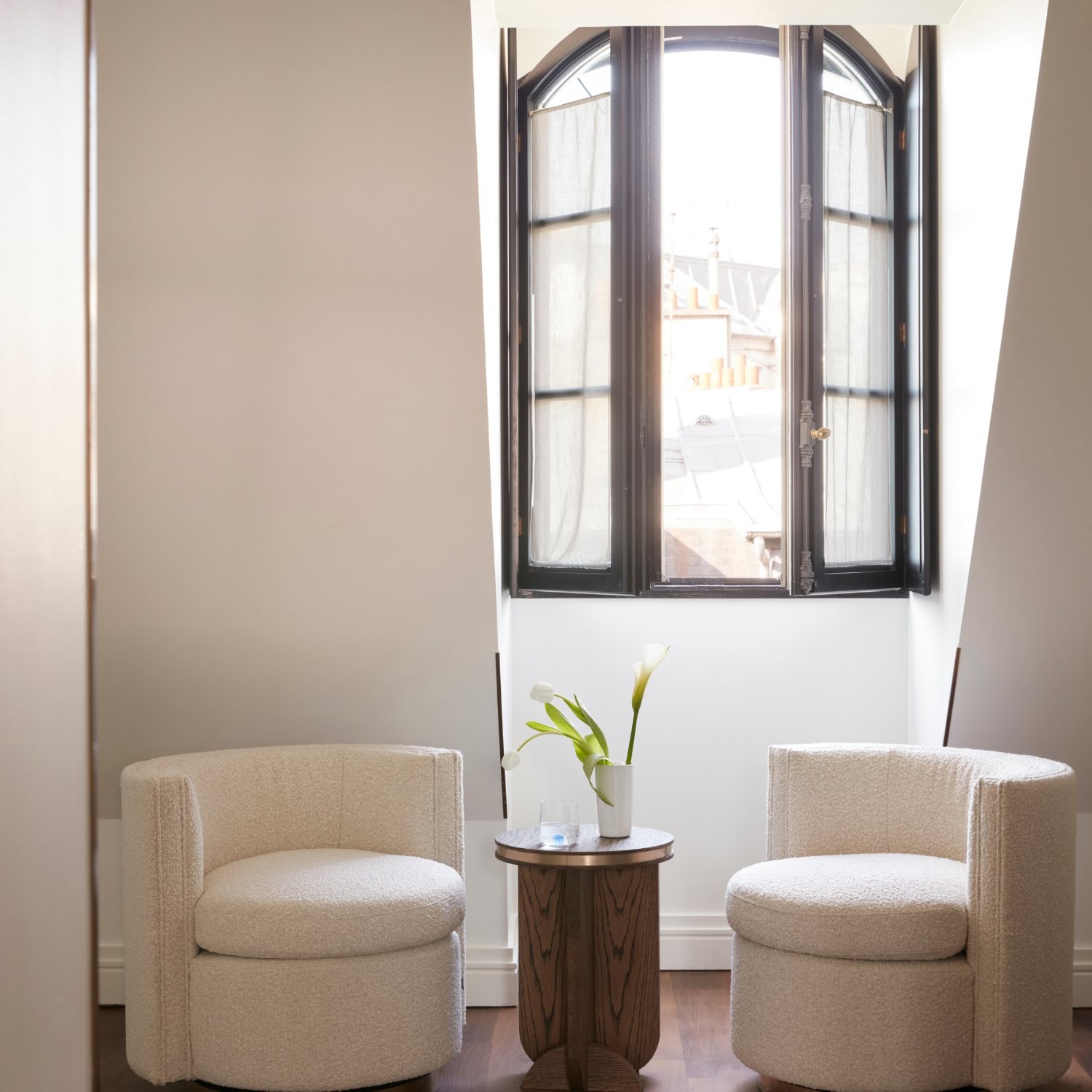 a seating area with two chairs next to a window