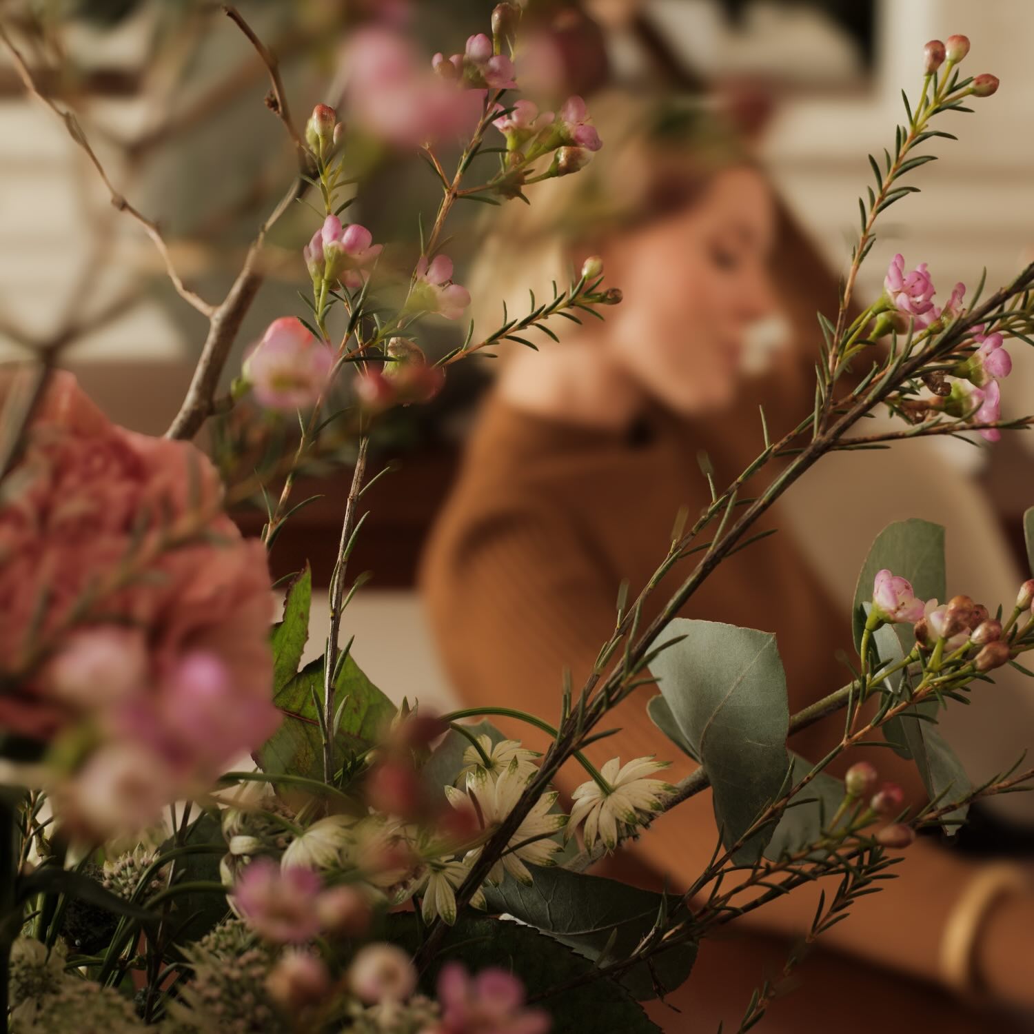 a woman sitting on a chair with a bouquet of flowers in front of her