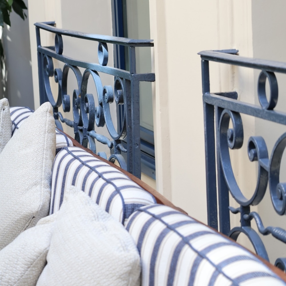 a close up of a blue and white striped bench located in the courtyard of maison delano paris