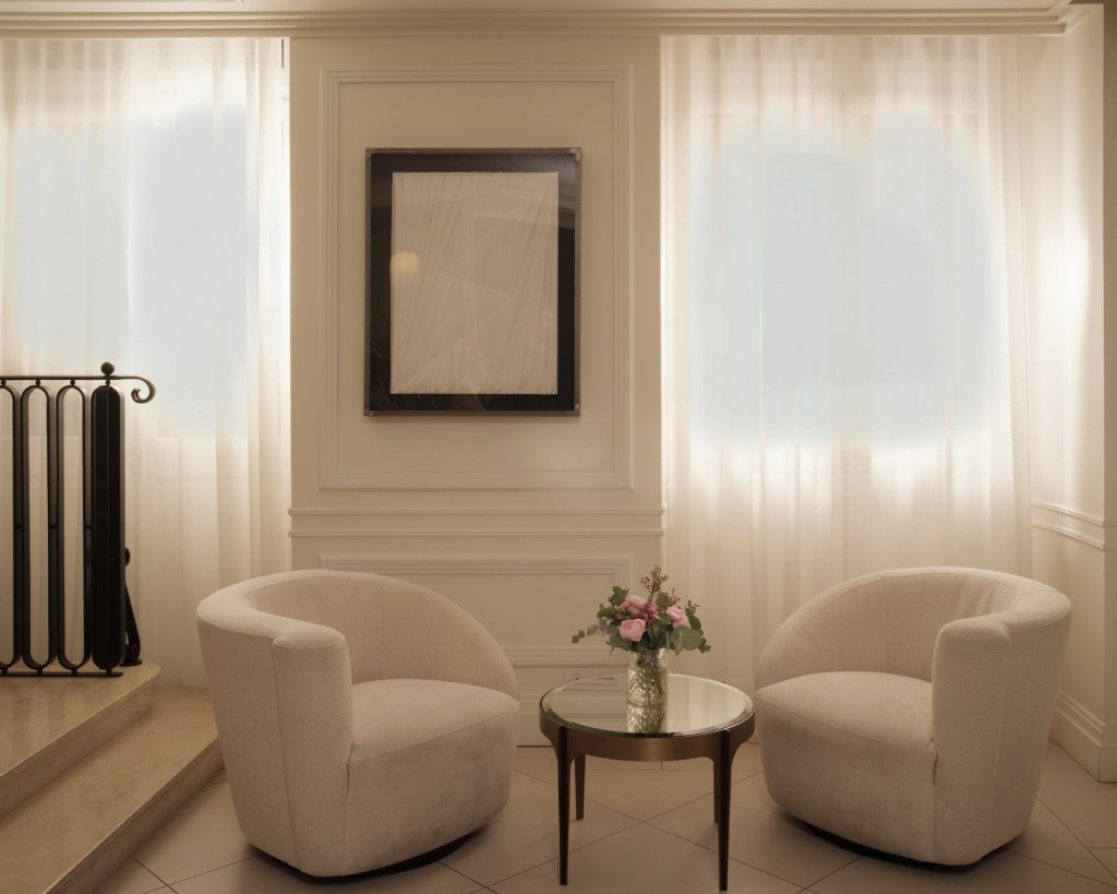 a seating area with two white rounded chairs