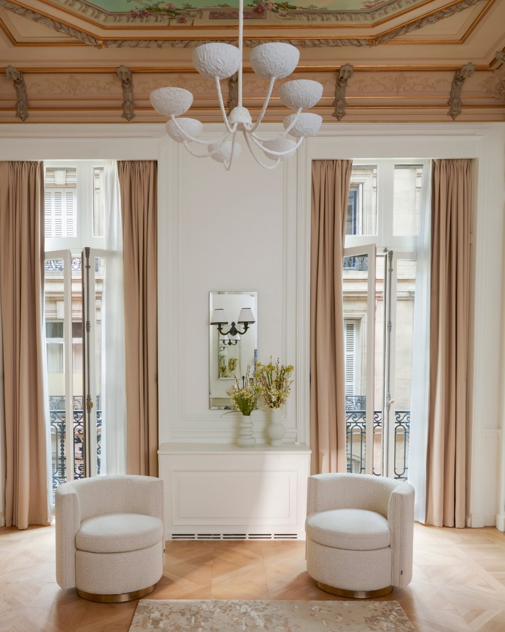 two white round chairs in a room with two glass doors leading outside