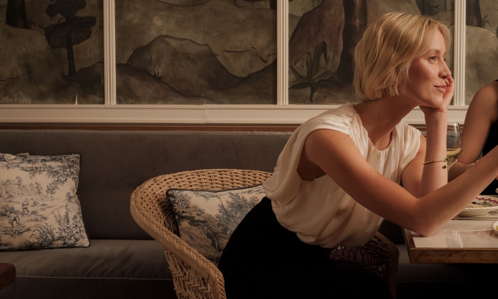 a woman leaning into conversation while dining at maison delano paris