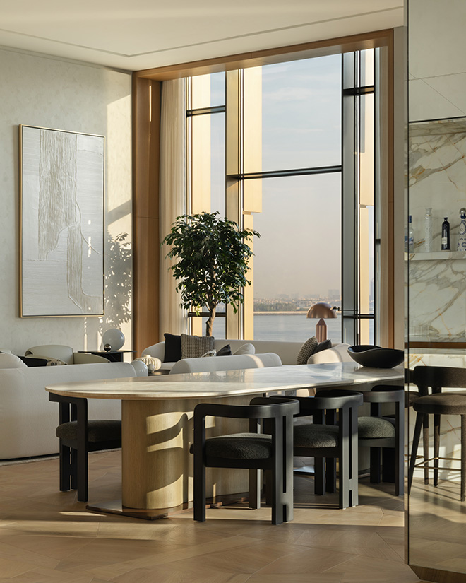 Living room and dining space in a penthouse with a large house plant alongside glass windows looking out over the water