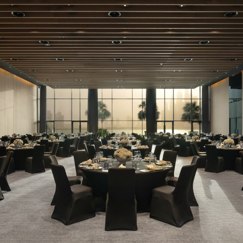 a large convention space with event round table style seating with flowers and decor