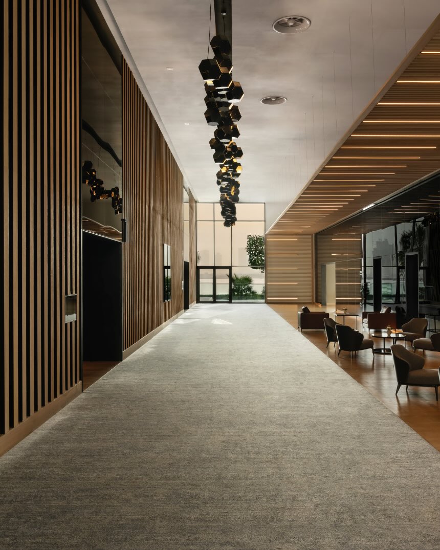 a foyer at delano dubai with seating area, wood paneling on the walls and a unique chandelier