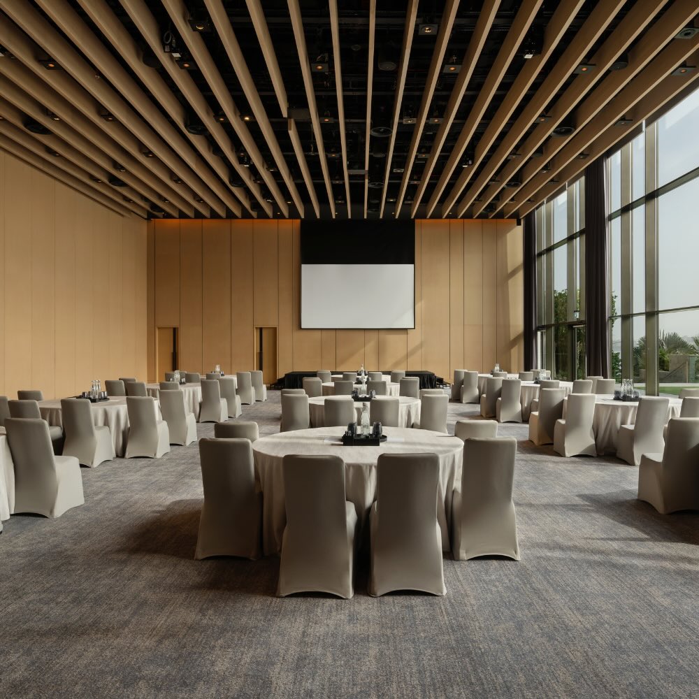 a large convention space with wood paneled ceilings and floor to ceiling windows