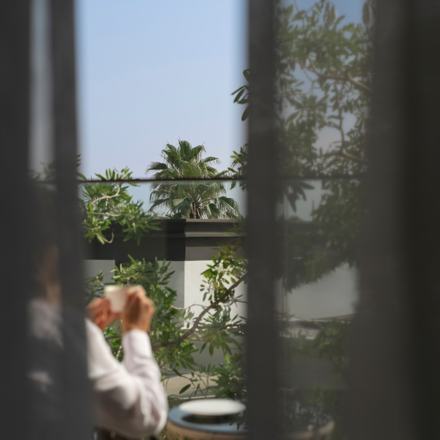 someone on the terrace holding coffee in their hands