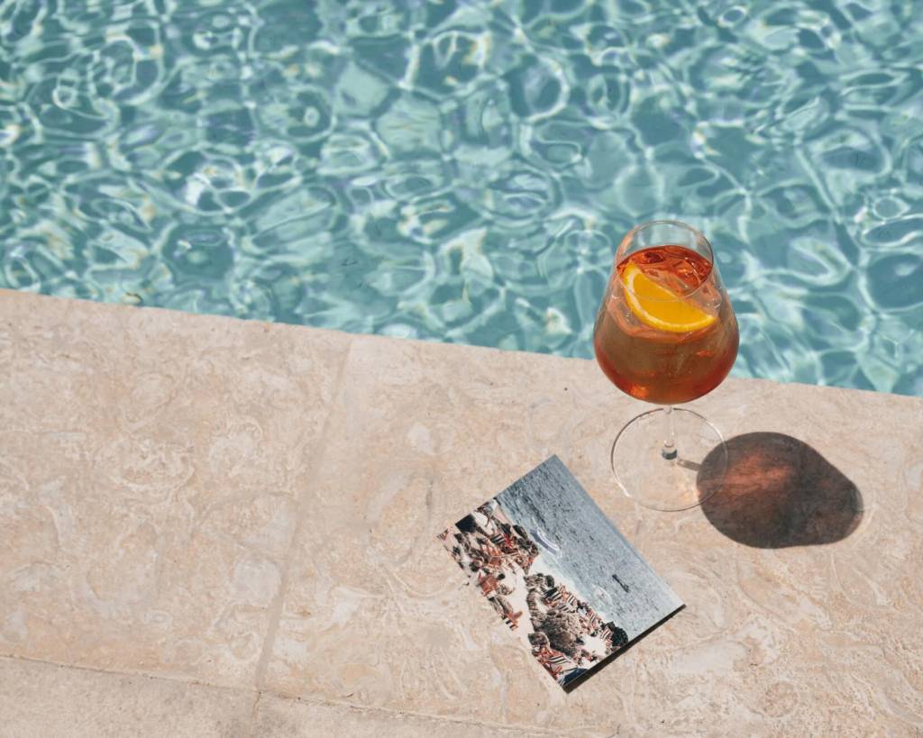 an aperol spritz placed on the pool deck