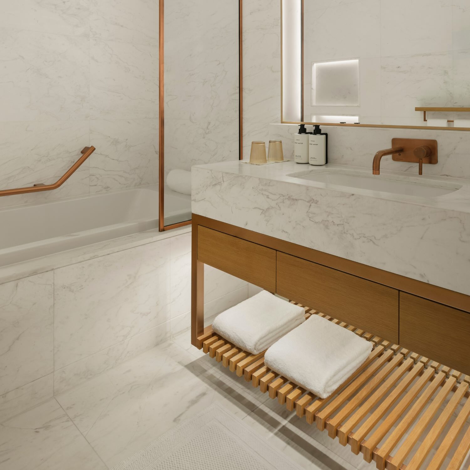 a white marble bathroom with wooden accents