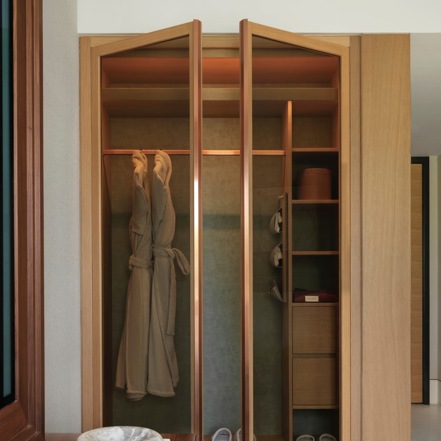 a large wooden closet with glass doors and shelving