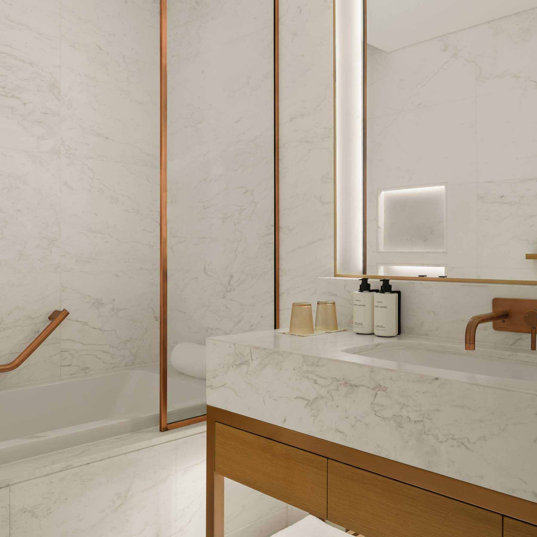 an elegant bathroom with white marble and gold finishes