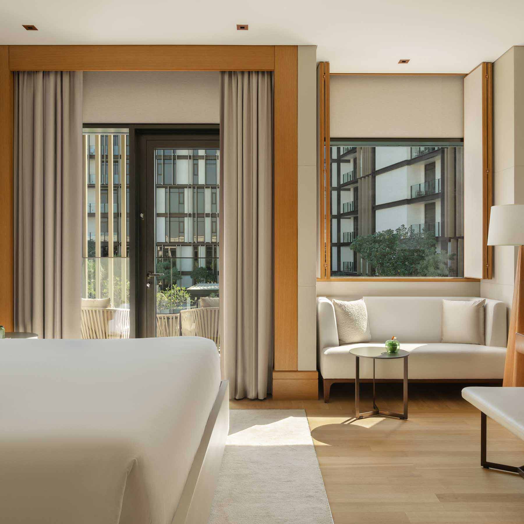 a rising light guest room with floor to ceiling windows a king bed and seating area with a white couch