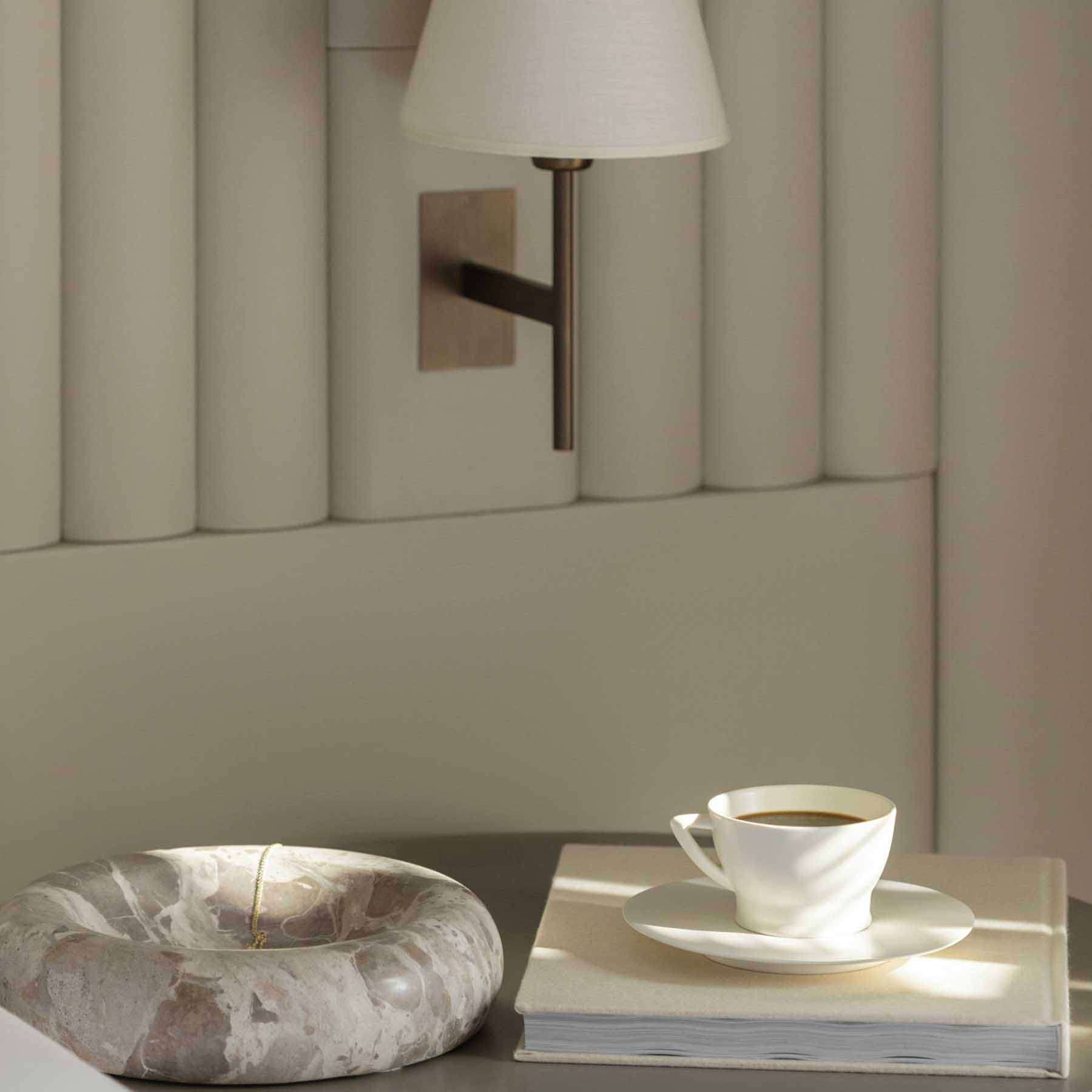 the bedside table with a cup of fresh coffee on top of it