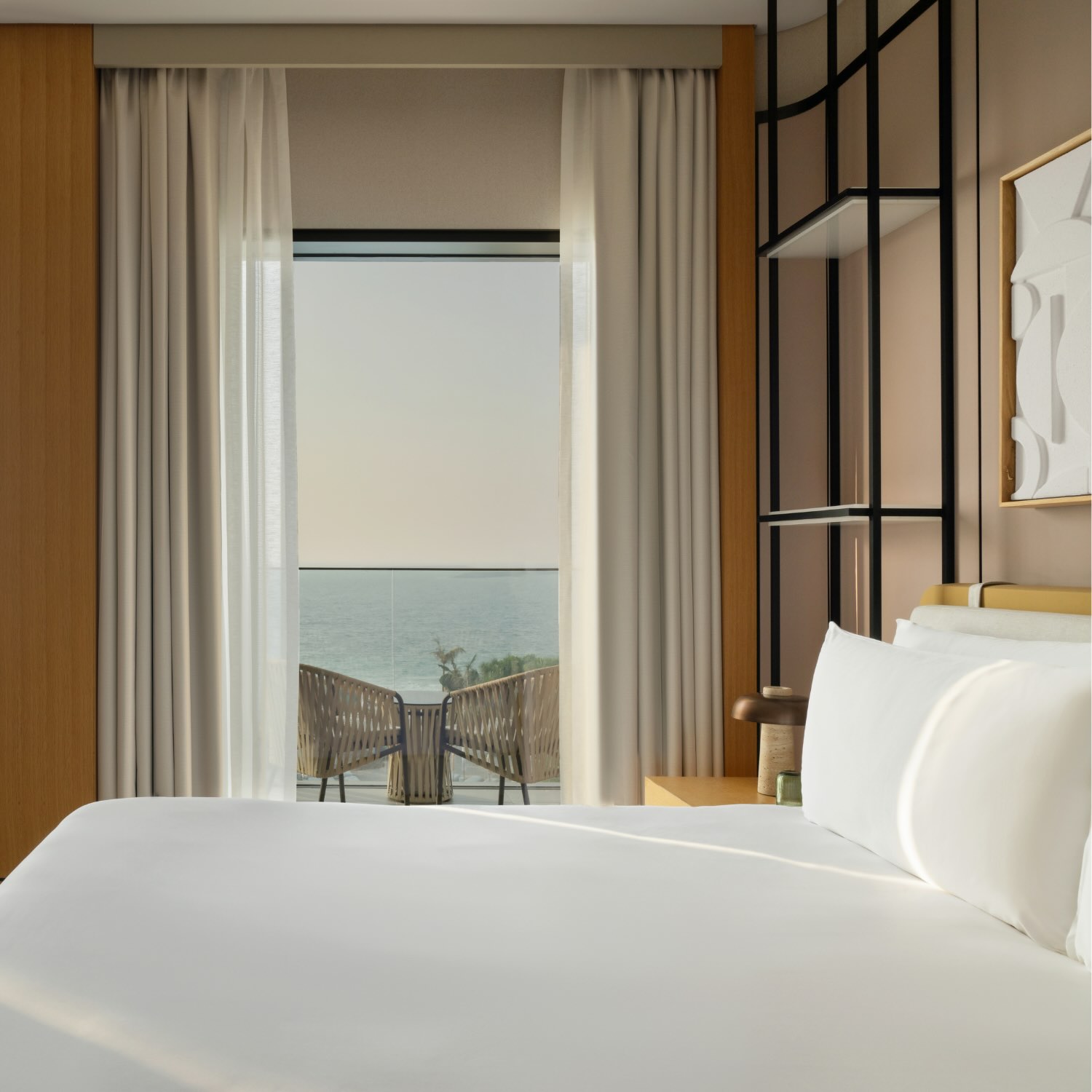 the side view of a bed in the collins suite with views of the ocean