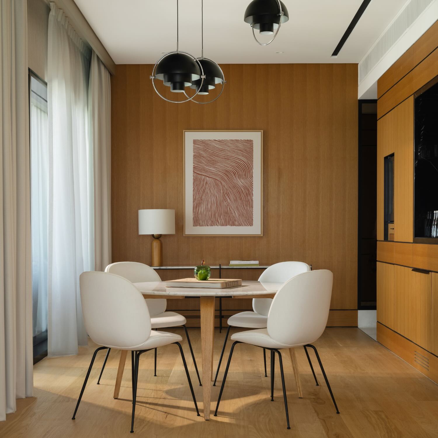 a dining area with 3 unique light fixtures 