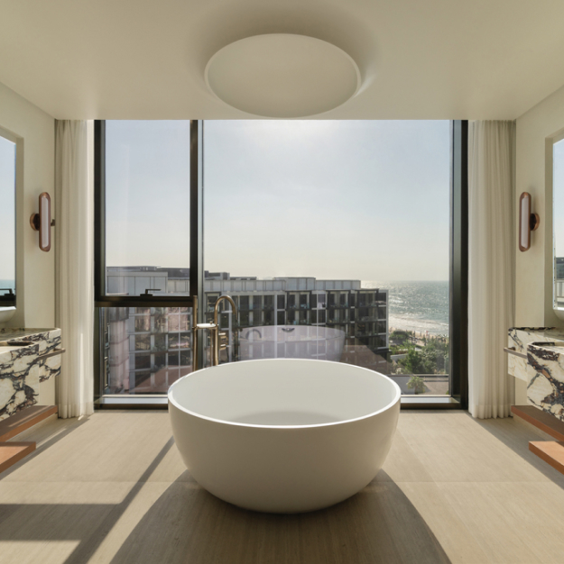 a large circular bathtub in the middle of a bathroom space