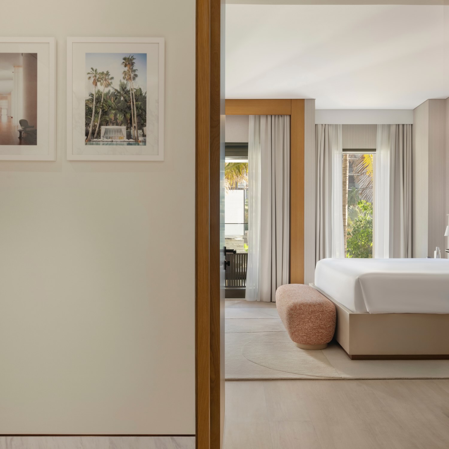 a peek into the bedroom from the bathroom, with floor to ceiling windows and natural light