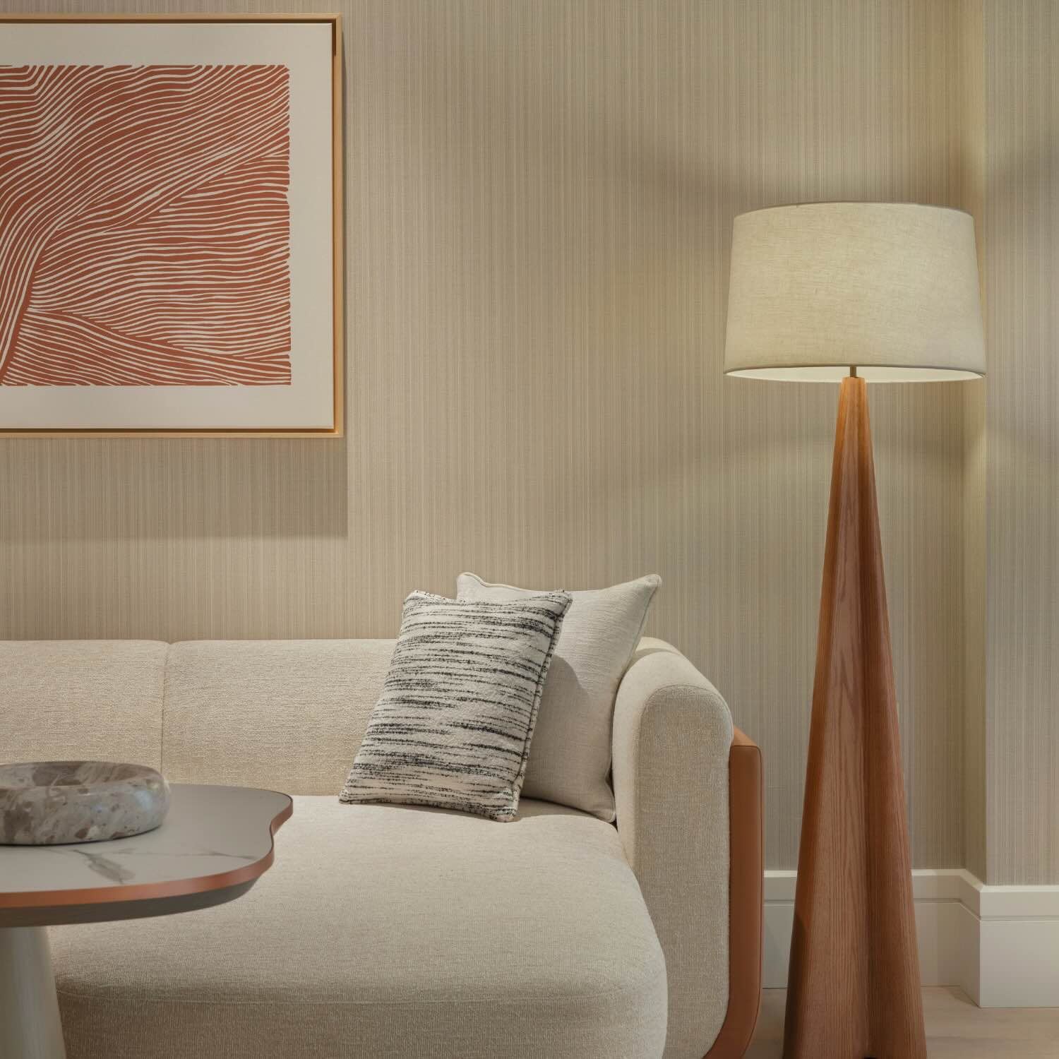 a white couch and naturally designed wooden floor lamp in the living area