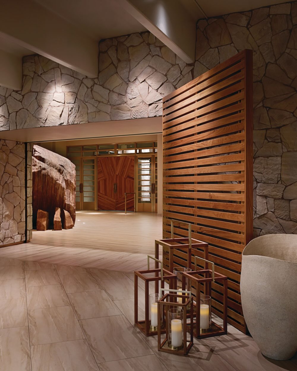 the entrance to the spa at delano las vegas, with natural rock and a large wooden door