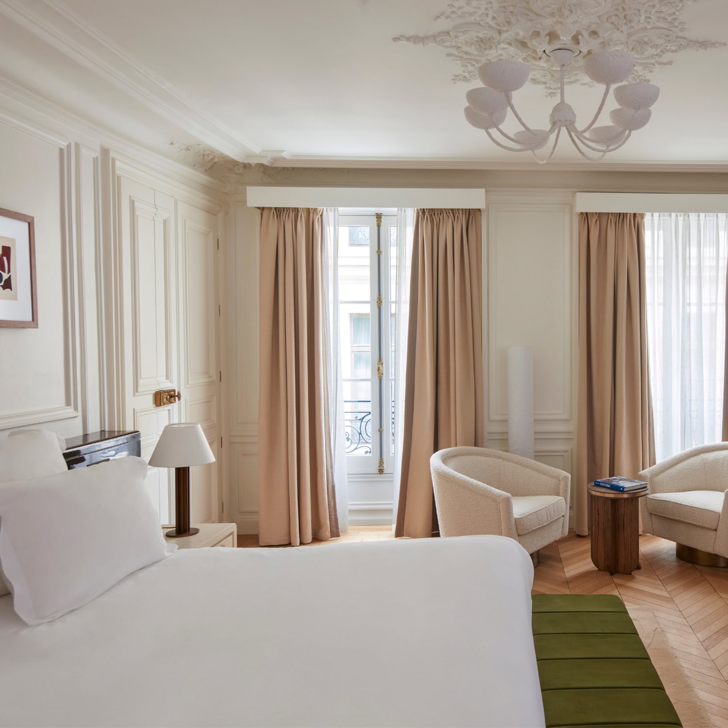 a bedroom in maison delano paris with two romantic windows and white chairs as a reading area