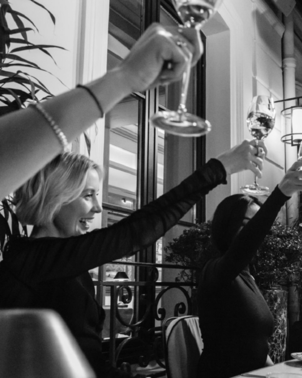 a black and white image of a large party raising their glasses