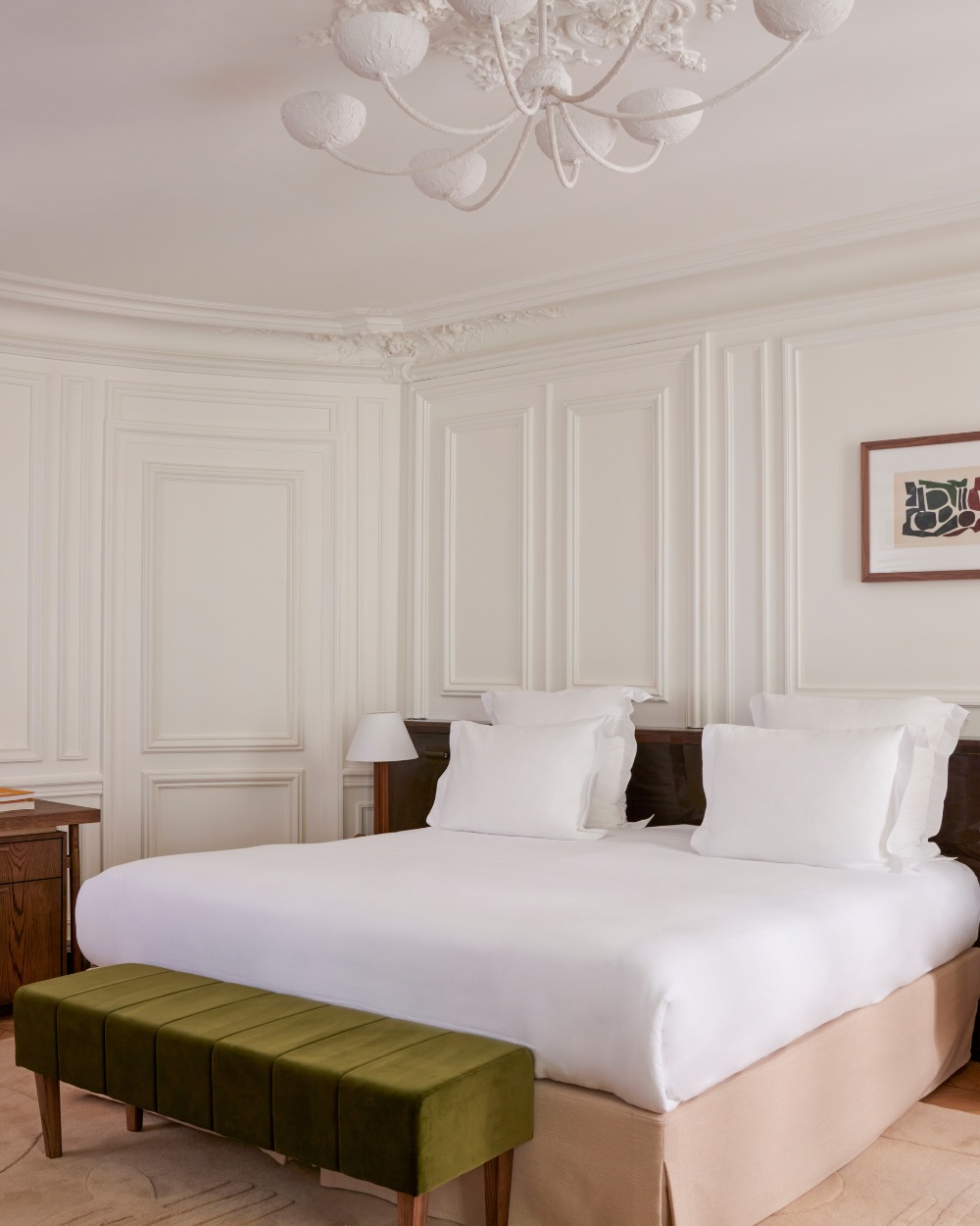 a room at maison delano paris with a king bed and a green velvet bench