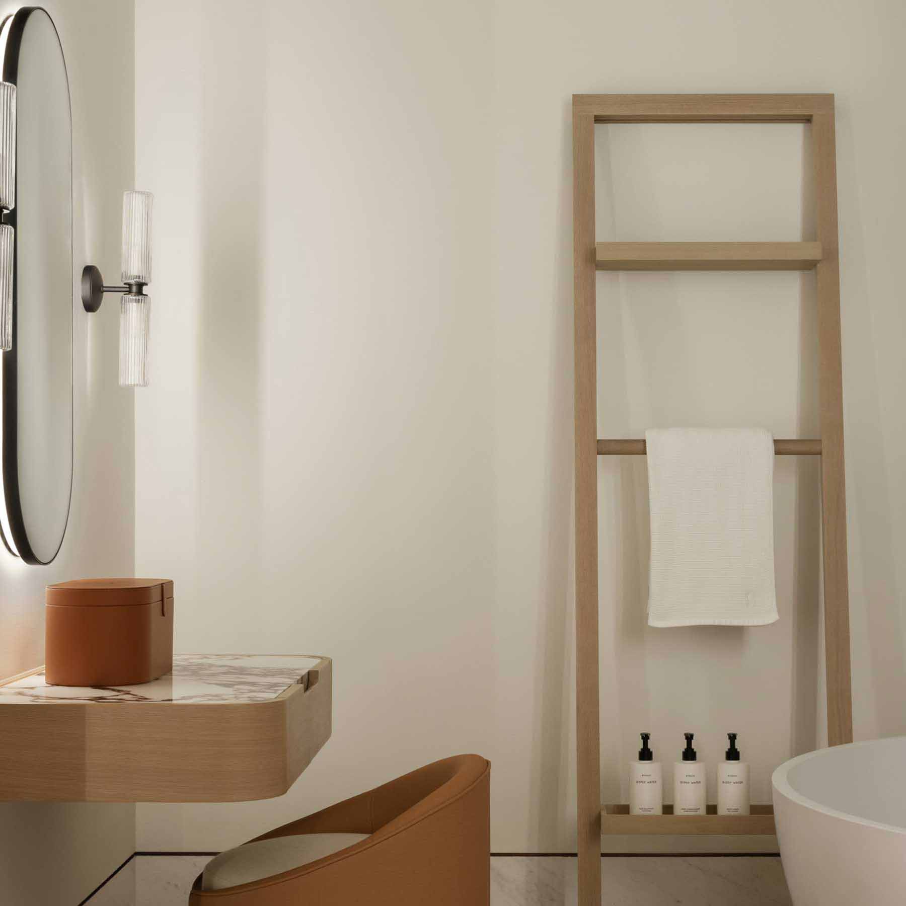 an elegant vanity with bright lighting and small chair