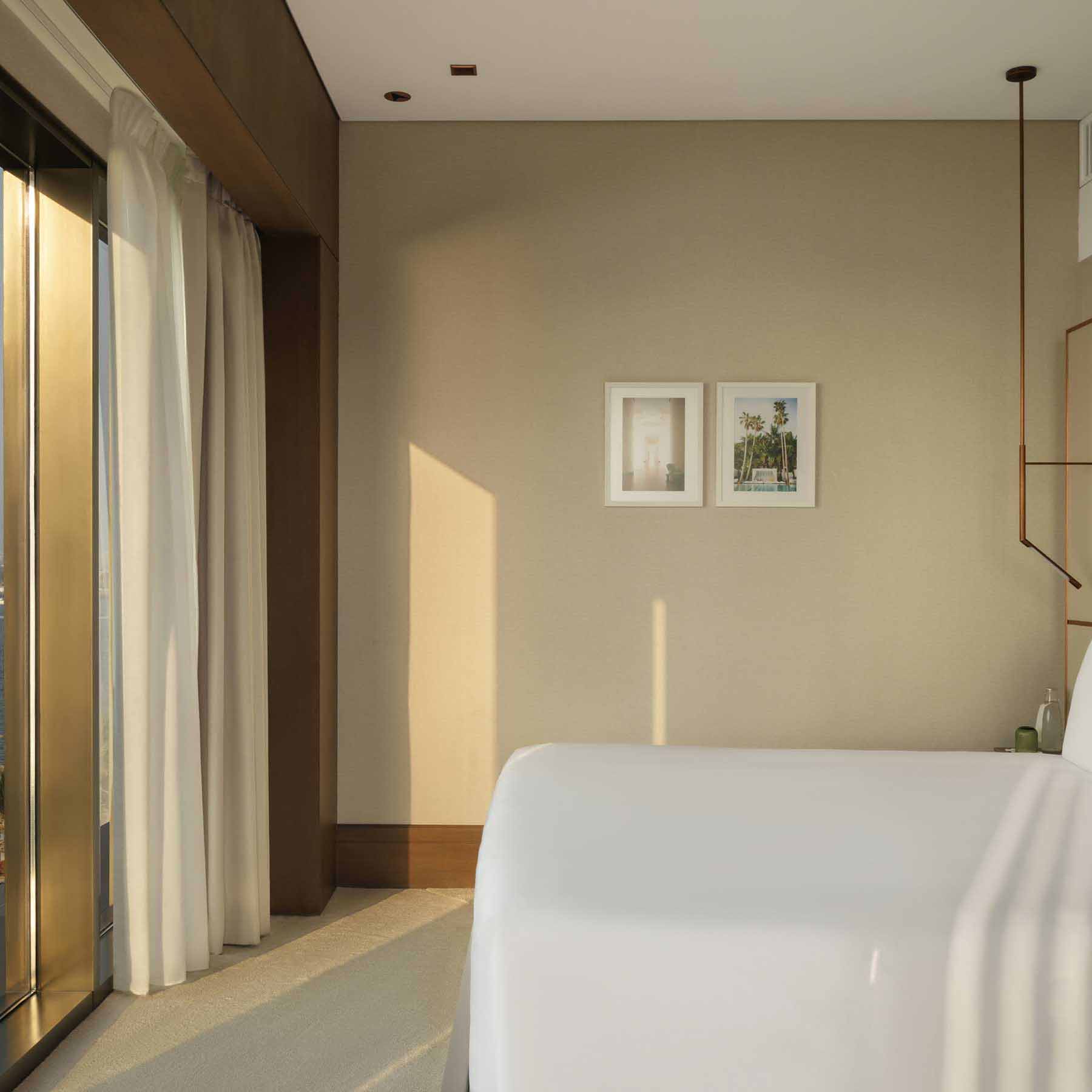 a bedroom with a king bed facing large windows with natural light