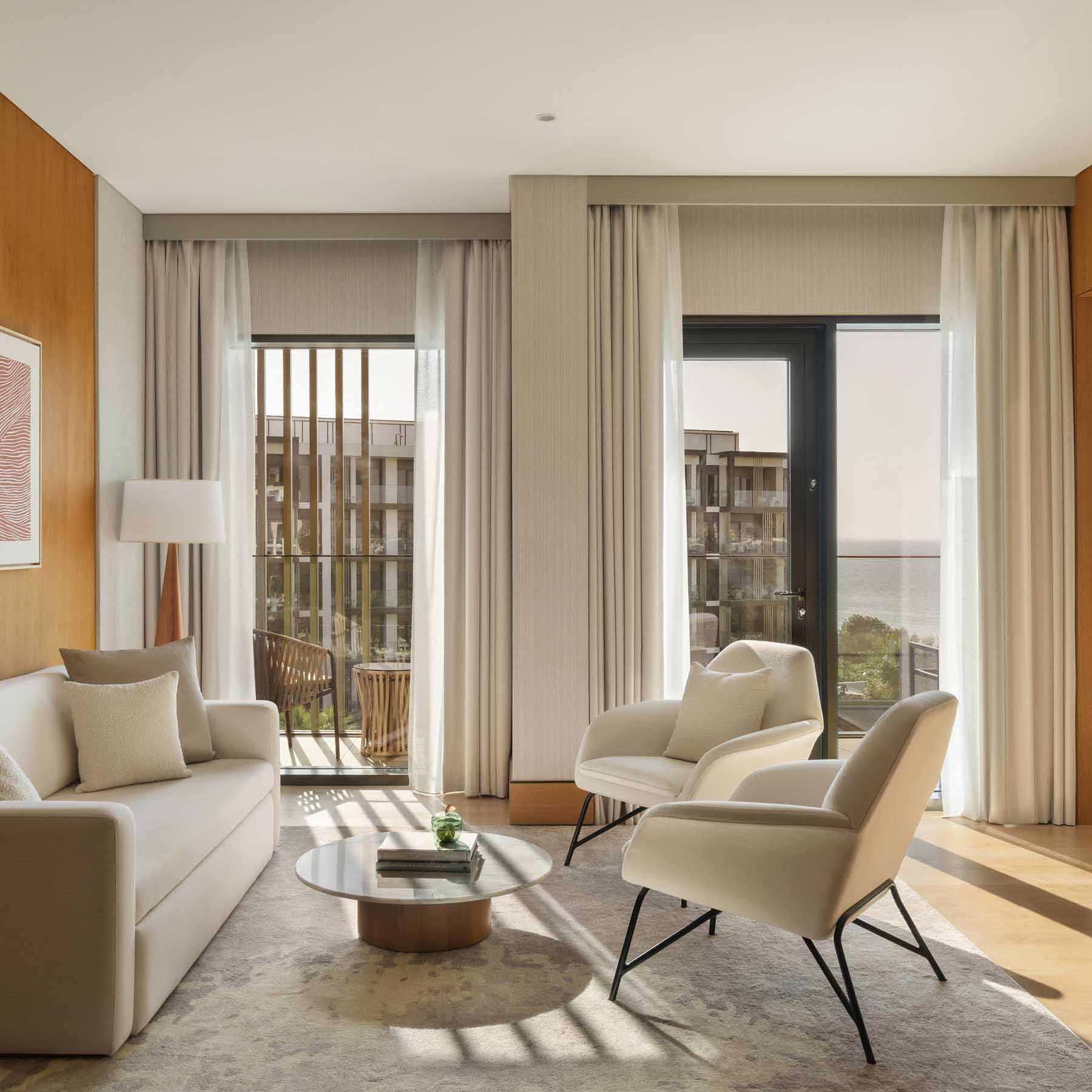a seating area with a white couch facing two chairs