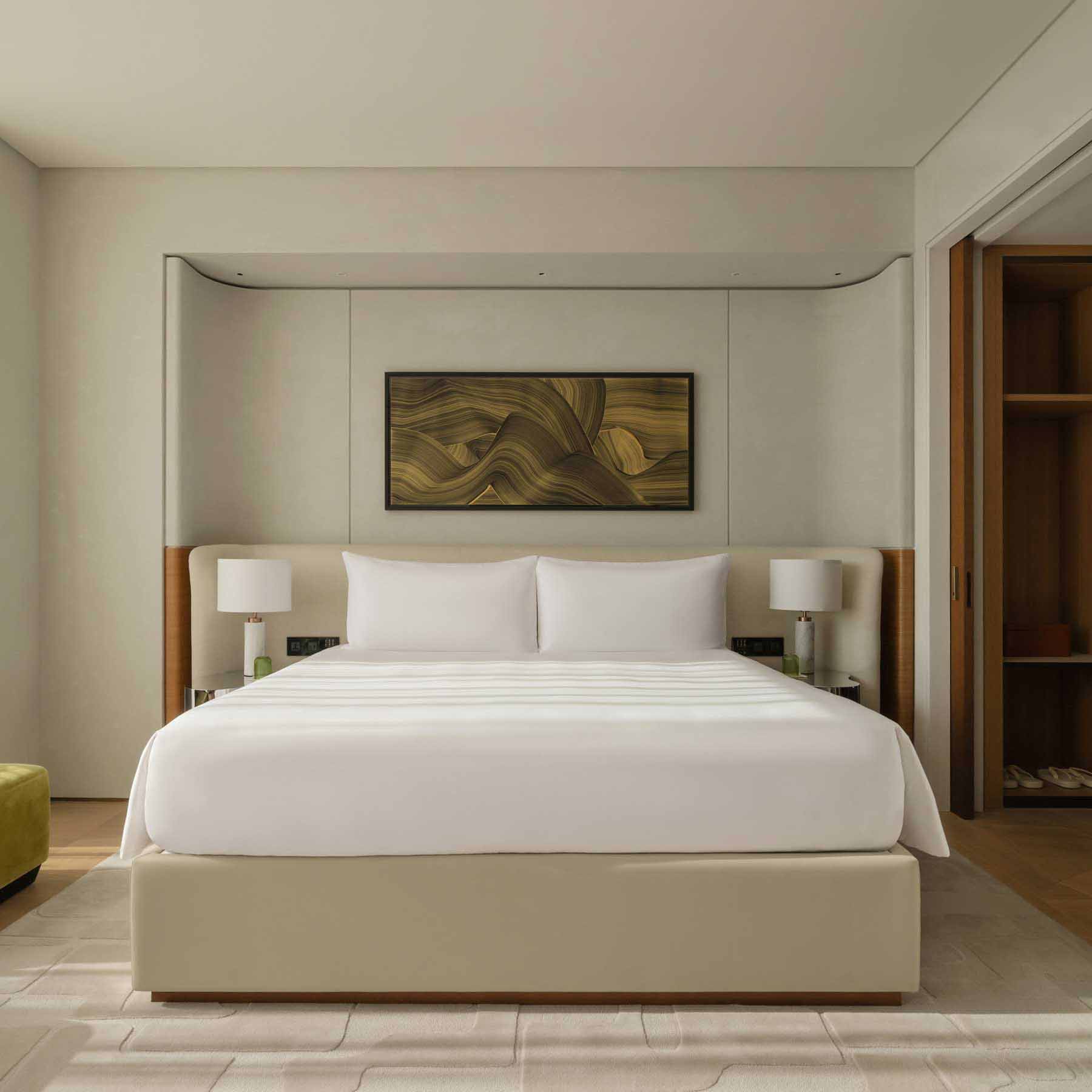 a king sized bed next to floor to ceiling windows