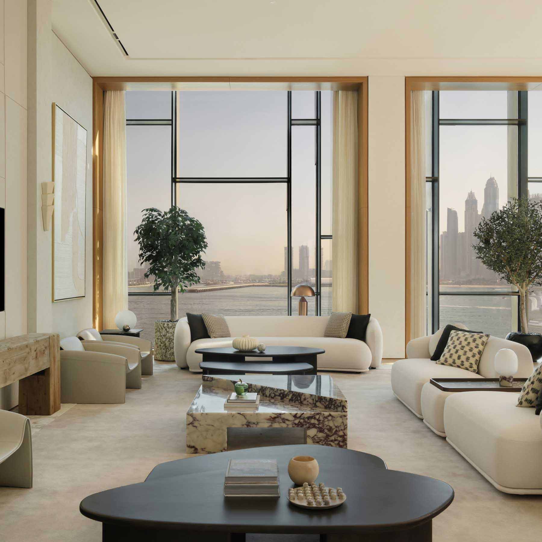 a large living space with a white couchand plentiful seating with tall ceilings and natural light