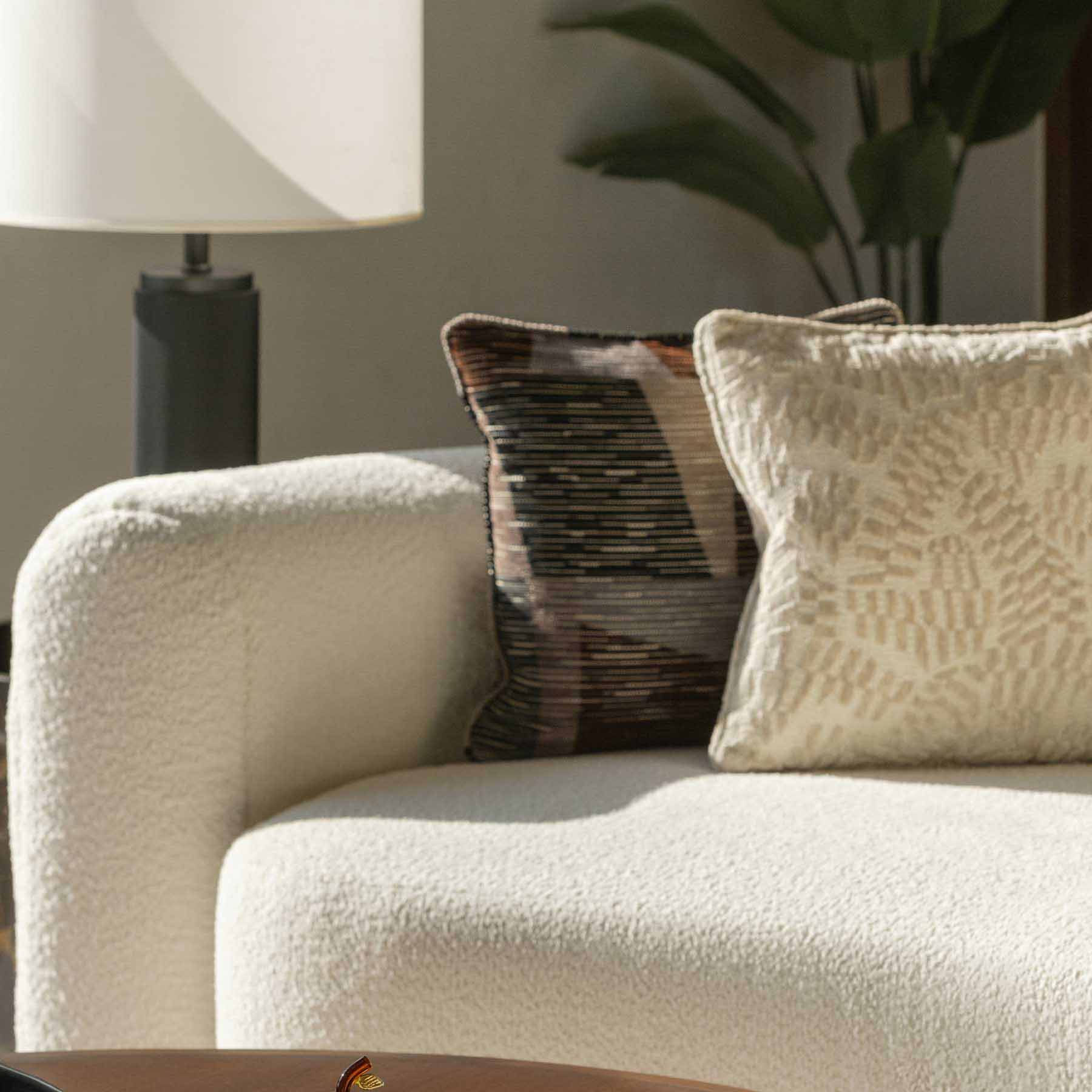 a detail shot of a white couch with elegant accent pillows