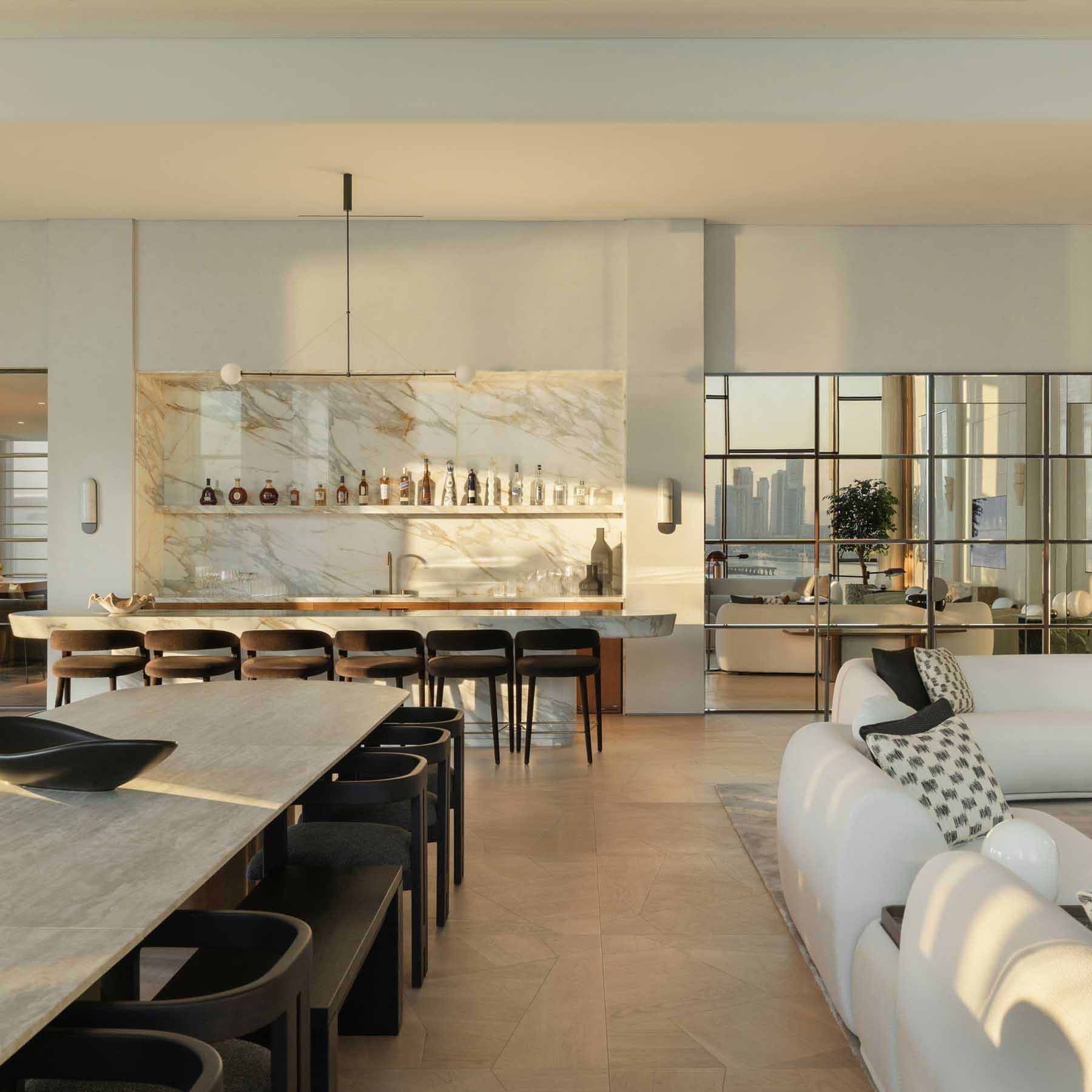 a large open plan living space with a bar, dining table and couches