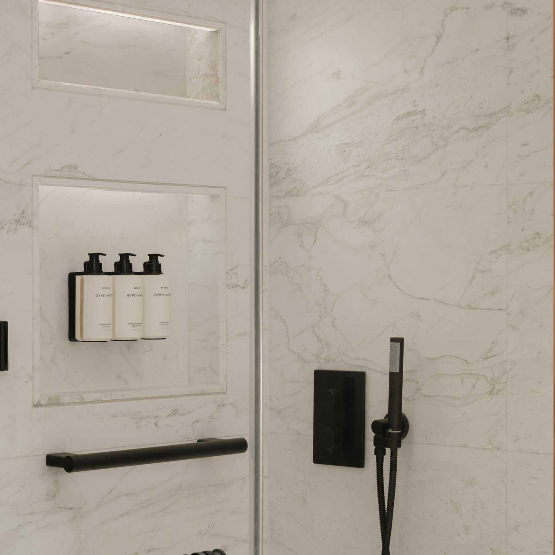 a standing shower with luxurious bath amenities provided