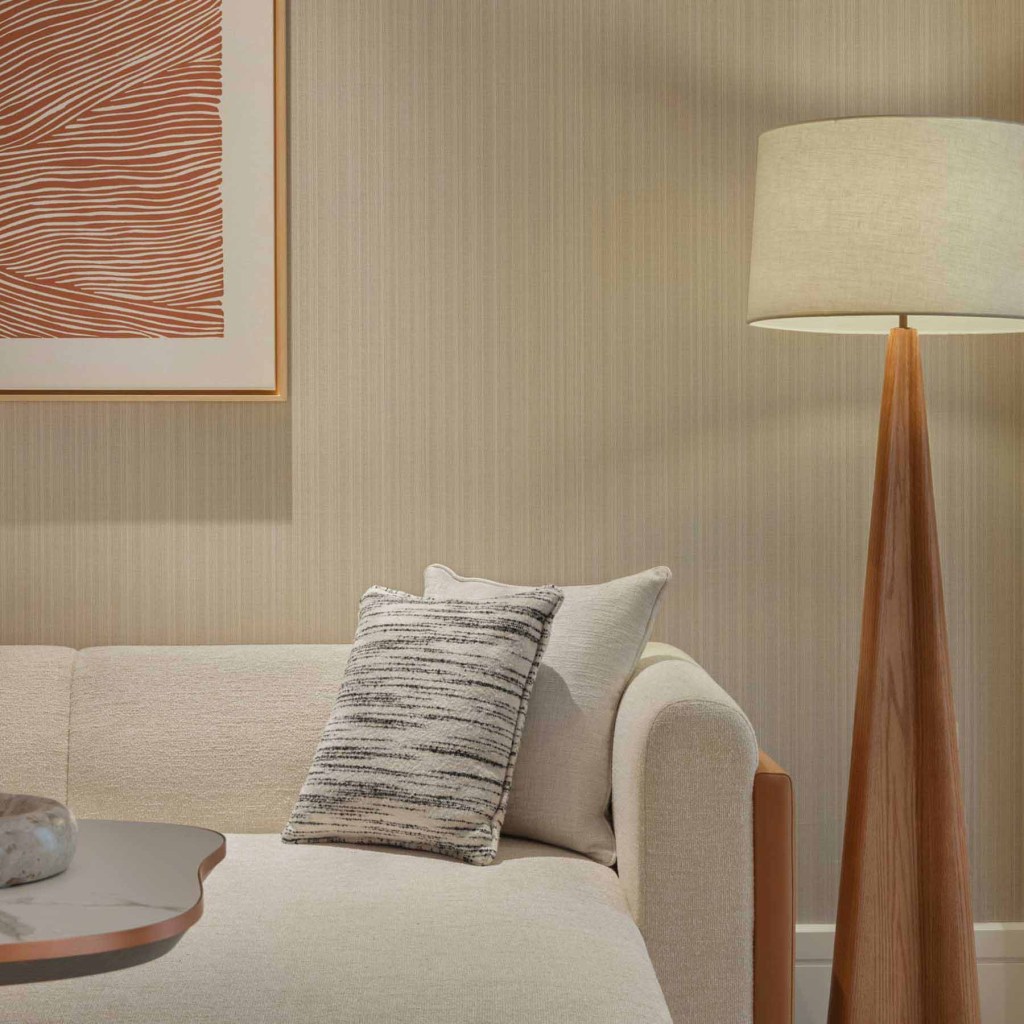 a white couch in the living space with a floor lamp with white shade