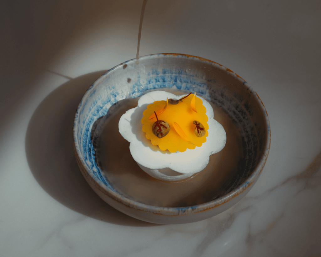 A delicious pavlova dessert, with delicate lighting on a marble table.